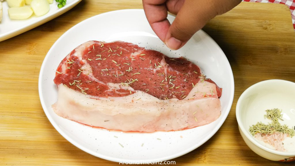 Add salt and rosemary to the steak 